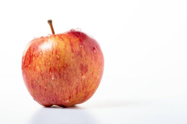 Beyaz arkaplanı olan tek bir elma üzerine su damlaları.