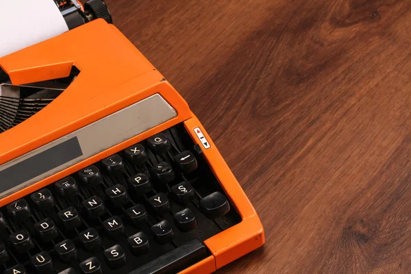 Die orangefarbene alte Schreibmaschine auf dem Holz — Stockfoto