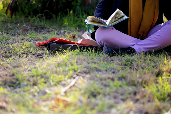 A college student reading book on grass — Stock Photo, Image