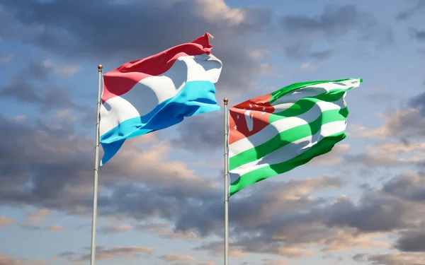 美丽的卢森堡国旗和阿布哈兹国旗在天空的背景下连在一起 3D艺术品概念 — 图库照片