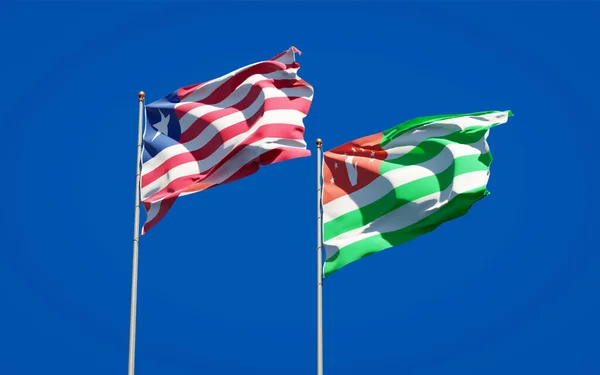 아름다운 라이베리아와 압하지야 국기가 하늘을 배경으로 있습니다 — 스톡 사진