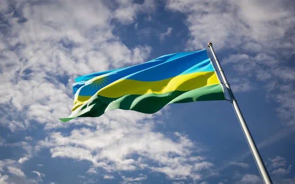 Beautiful national state flag of Rwanda fluttering at sky background. Low angle close-up Rwanda flag 3D artwork.
