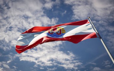 Polinezya 'nın güzel ulusal bayrağı gökyüzü arka planında dalgalanıyor. Düşük açılı Polinezya bayrağı 3D sanat eseri.