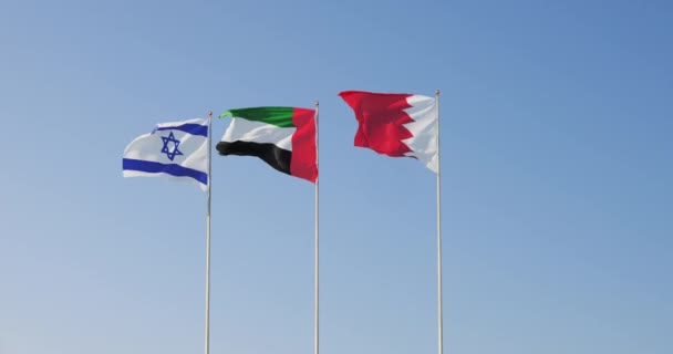 Banderas de Emiratos Árabes Unidos, Israel y Bahréin ondeando juntas en el cielo. Relaciones internacionales. — Vídeo de stock