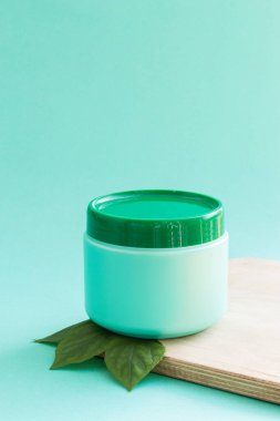 Yeşil bir arka planda boş bir açık yeşil şampuan şişesi ya da saç kremi. Doğal güzellik konsepti