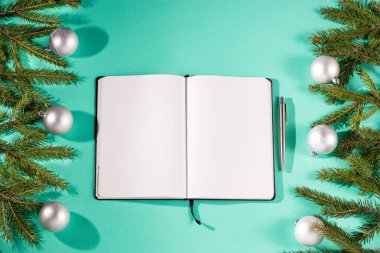 Noel 'de köknar dalları ve turkuaz arka planda gümüş süslemeler ve fotokopi alanı. Noel tebrik kartları ve makaleleri için görüntü. Kış, Yeni Yıl, Noel konsepti