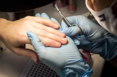 Adım adım manikür işlemi. Manikür için talimatlar. Güzellik konsepti. Kişisel bakım konsepti. Kadın ellerine yakın çekim. Eldivenli güvenli manikür. Güzellik küresiyle ilgili siteler için görüntü