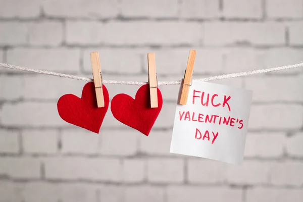 Valentine's day composition. Red hearts hanging on the clothespins. with a note 