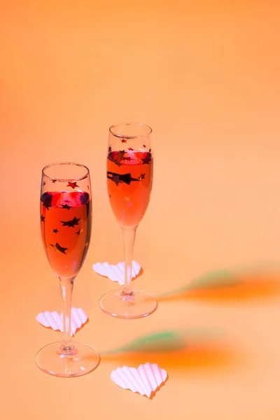 Twee Champagne Glazen Oranje Achtergrond Met Kleurrijke Schaduwen Samenstelling Voor — Stockfoto