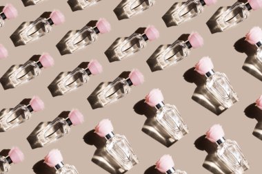 Pastel bej arka planda bir kadın parfümü deseni, üst manzara, düz yatak. Parfüm şişelerinin maketi