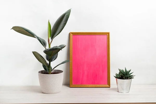 Kopya alanı olan Pembe Poster. Ev bitkisi fihristi ve kaktüs içeren bir çerçeve. İskandinav tarzı iç mekan. Beyaz, minimalizm