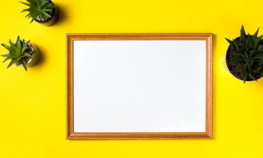 Beyaz kart modeli, ev bitkileri, kalem, sarı arka planda gözlük. Minimalizm kavramı. Uzayı kopyala İş yeri. 2021 yılının trend rengi