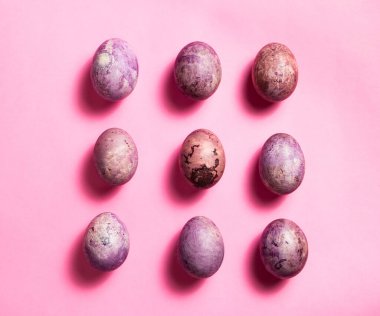 Pembe yüzeyde renkli dokuz yumurta. Fotokopi alanı olan bir Paskalya dairesi. Tebrik ve davet kartları için resim.