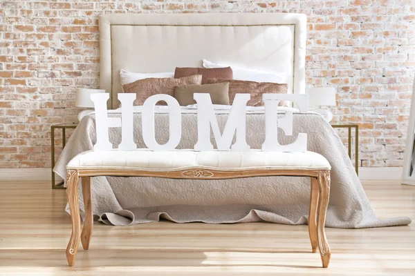 Home letters sign in interior near bed closeup — Stock Photo, Image