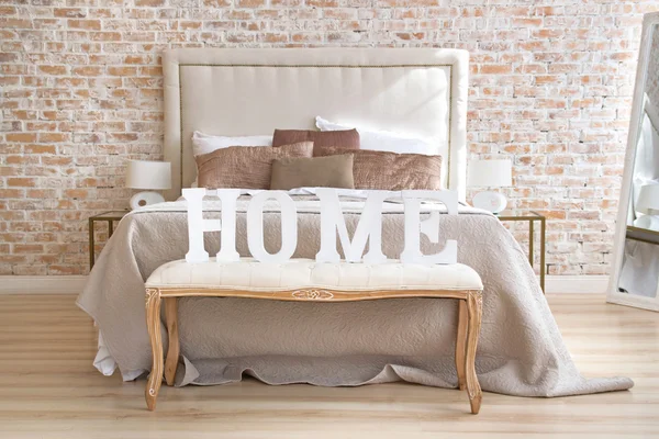 Home letters sign in interior near bed — Stock Photo, Image