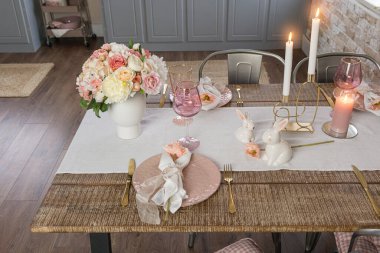 Romantik masa dekorunun, gözlüklü çiçeklerin ve yanan mumların yan görüntüsü. Ahşap bir masada düğün Paskalya bayramı hazırlığı.