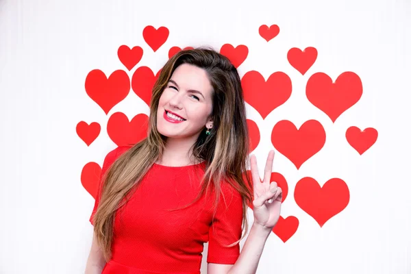 White caucasian woman with red lips giving a counting hand (two sign) on a heart shaped background.Valentines day — Stock Photo, Image