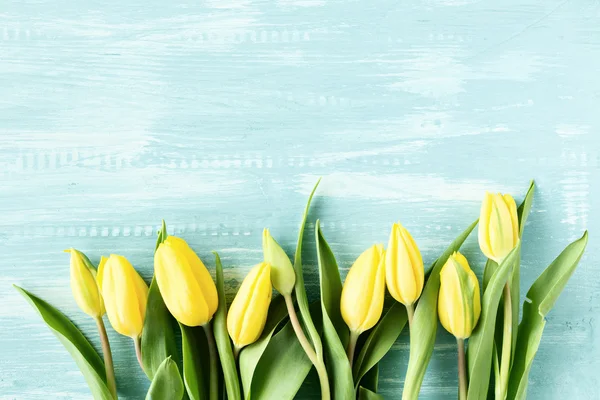 Yellow tulips over wooden table — Stock Photo, Image