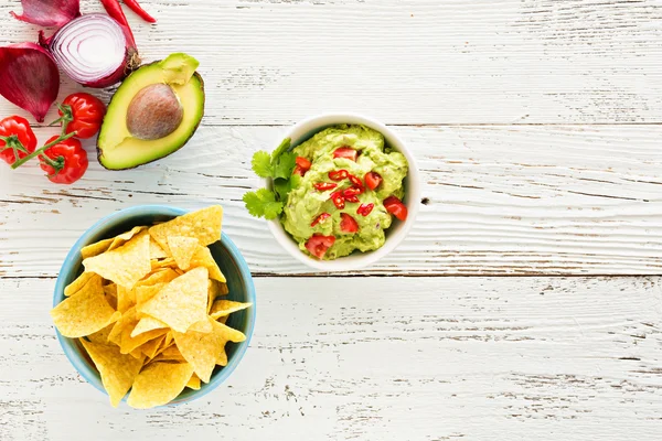 Guacamole com abacate e tomate comida mexicana. fundo de madeira branco — Fotografia de Stock