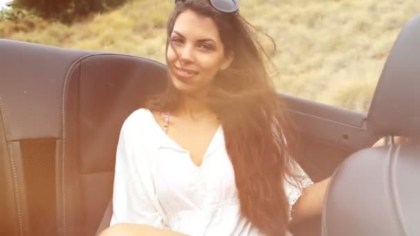 Mujer joven en el asiento trasero de un convertible. sensación de verano — Vídeos de Stock