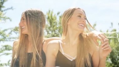 kadın ikiz güneşin altında eğlenmek. toz ve sızıntıları. HD