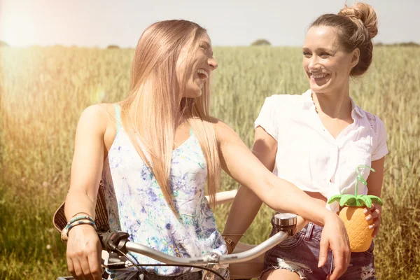 Meninas gêmeas na moda fazendo um passeio de bicicleta. sentimento de verão. edição de cor — Fotografia de Stock