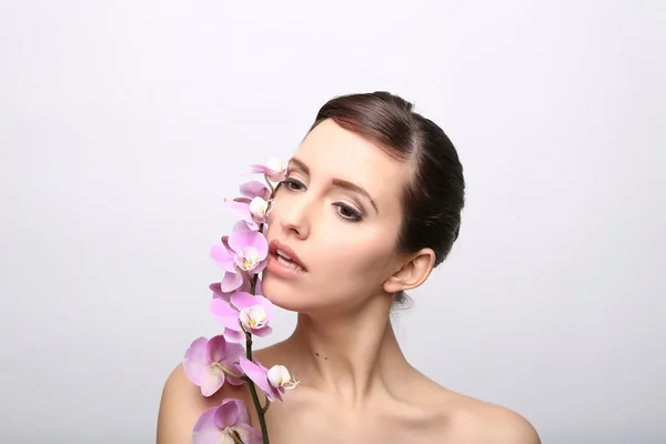 Menina bonita com flores da orquídea . — Fotografia de Stock