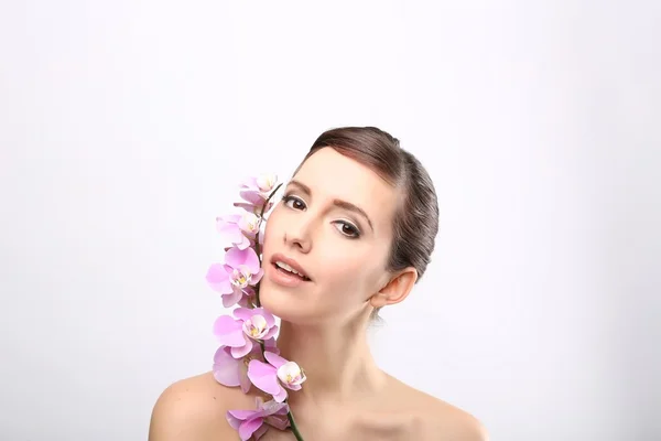 Menina bonita com flores da orquídea . — Fotografia de Stock