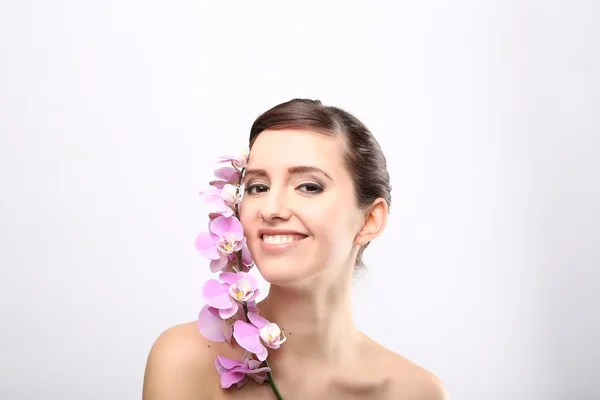 Menina bonita com flores da orquídea . — Fotografia de Stock