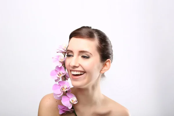 Menina bonita com flores da orquídea . — Fotografia de Stock