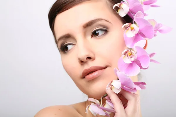 Krásná dívka s květy orchidejí. — Stock fotografie