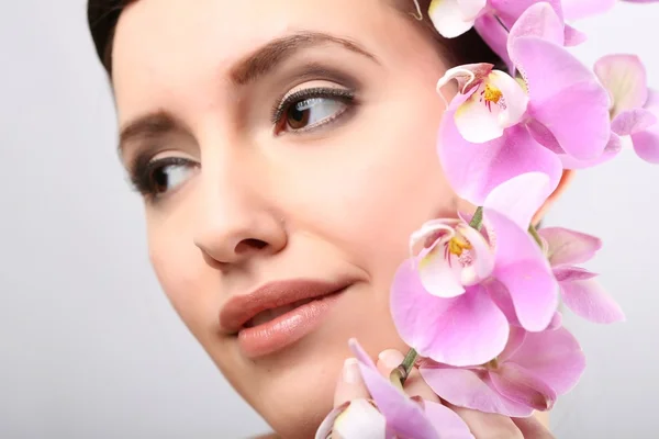 Menina bonita com flores da orquídea . — Fotografia de Stock