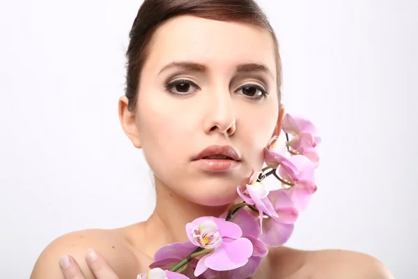 Menina bonita com flores da orquídea . — Fotografia de Stock