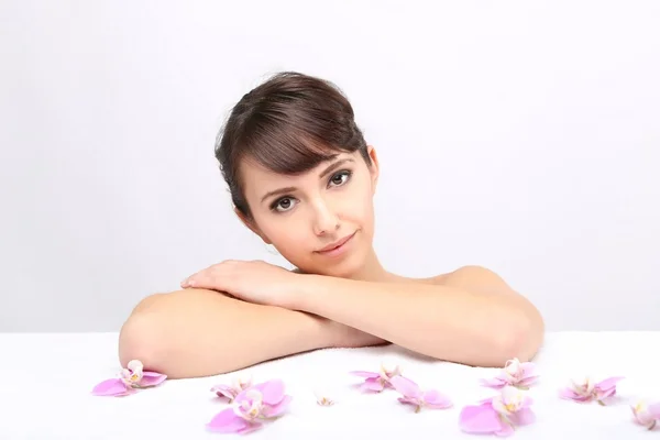 Salón de spa. Chica acostada en una mesa de masaje — Foto de Stock