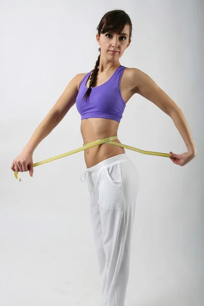 Beautiful woman measuring her waist — Stock Photo, Image
