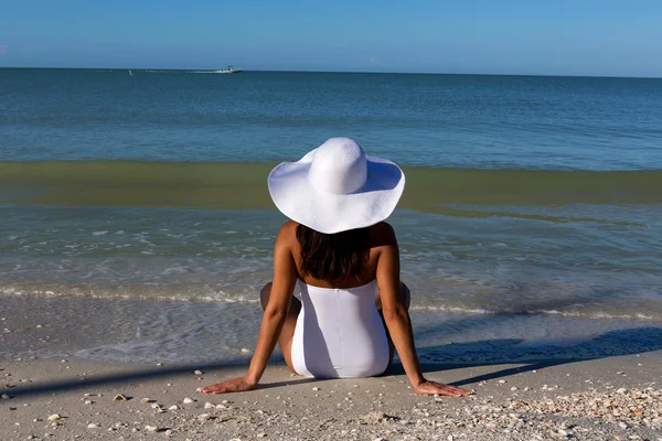 Kvinna sitter på stranden — Stockfoto