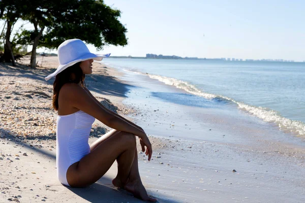 Frau sitzt am Strand — Stockfoto