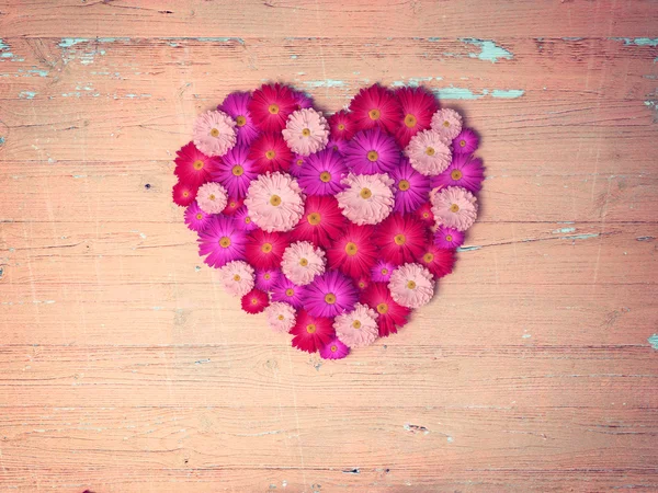 Vintage corazón de flores sobre mesa de madera — Foto de Stock