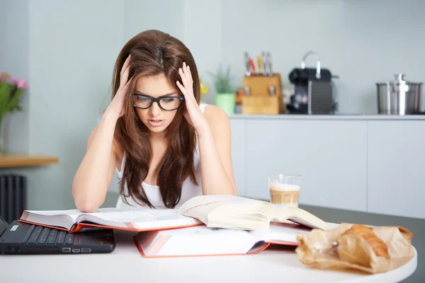 Mujer joven feliz estudiando en la cocina — Foto de Stock