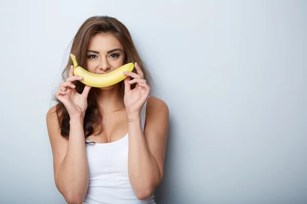 Woman making fun with a banana — Stock Photo, Image