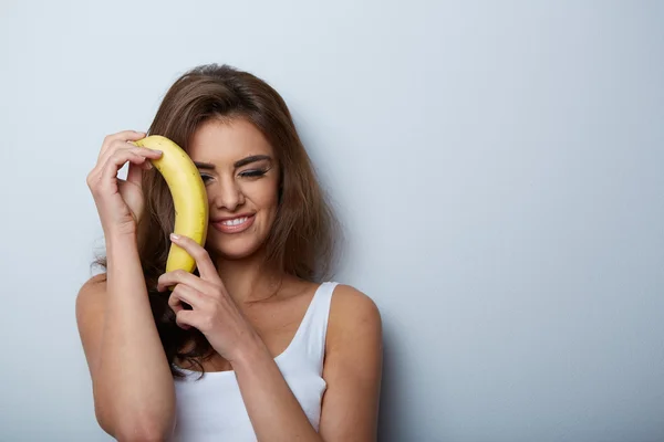 Woman making fun with a banana — Stock Photo, Image