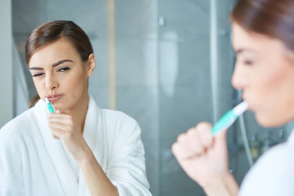 Unga vackra kvinnan borsta tänderna — Stockfoto