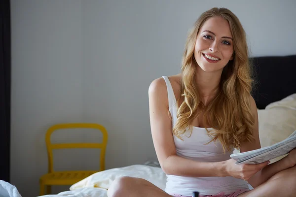 Feliz rubia sonriente en la cama blanca — Foto de Stock