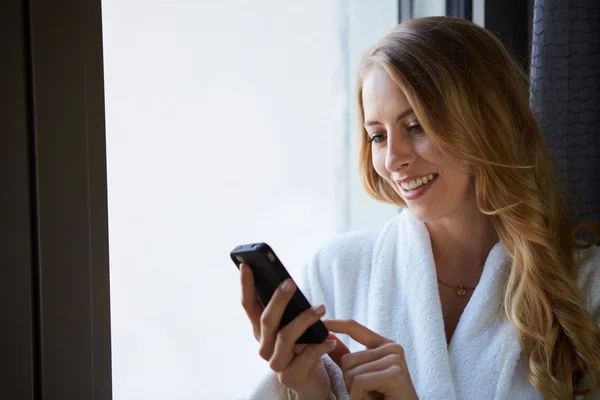 Young woman talking on the phone and drinking coffee — Stock Photo, Image