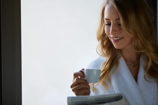 Young woman talking on the phone and drinking coffee — Stock Photo, Image