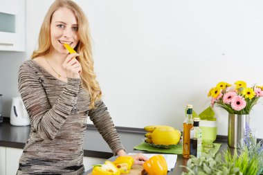 sarışın kadın pişirmek için bir tablet bilgisayar kullanma