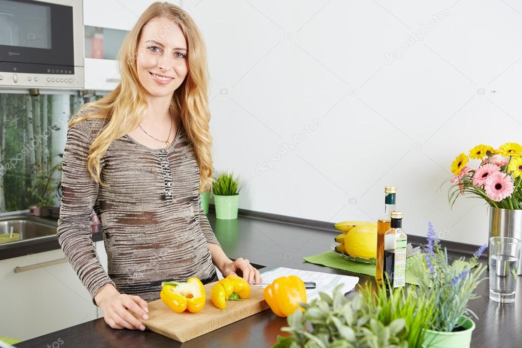 Blonde woman using a tablet computer to cook