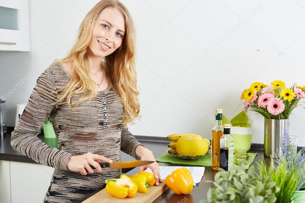 Blonde woman using a tablet computer to cook