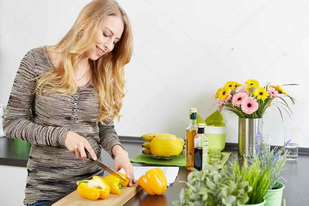 Blonde woman using a tablet computer to cook