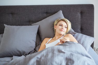 kafasını yanında elleriyle yatakta istirahat kadın